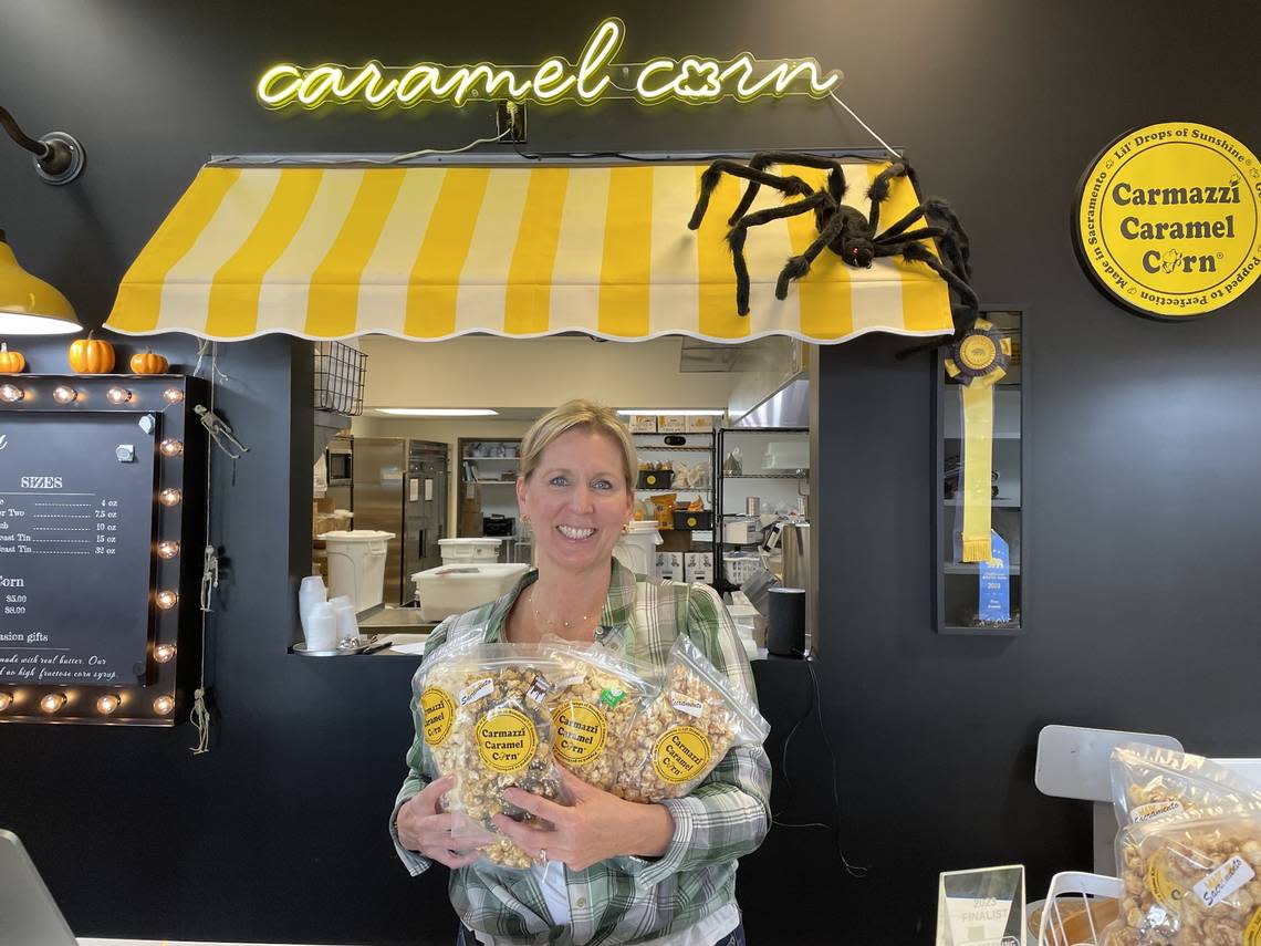 Founder Karen Carmazzi of Carmazzi Caramel Corn at 520 La Sierra Drive, Sacramento, holds bags of her popcorn in October. Service journalism reporter Brianna Taylor visited the family-owned business on a $25 budget as part of The Sacramento Bee’s affordability series.