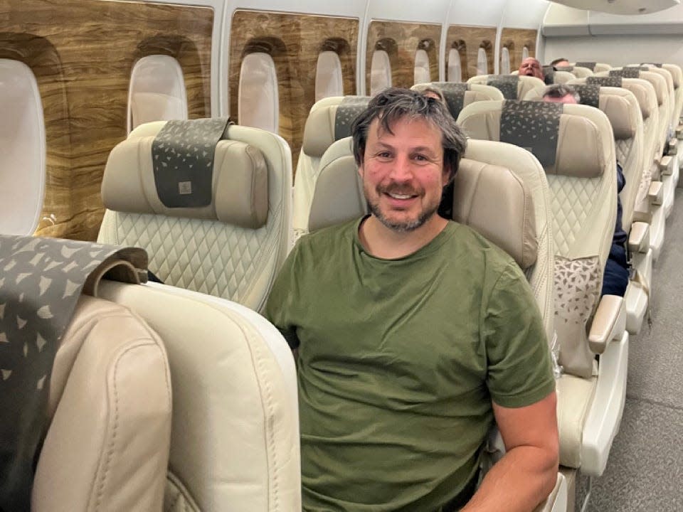 Autor Ash Jurberg sitzt im Flugzeug in der Premium Economy 