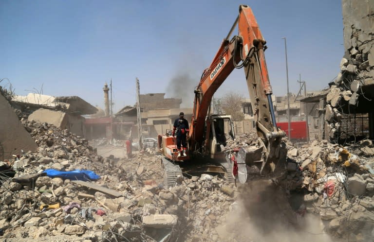 Iraqi civil defence and rescue workers search for the bodies of victims under the rubble in western Mosul's Zanjili district on July 26, 2017