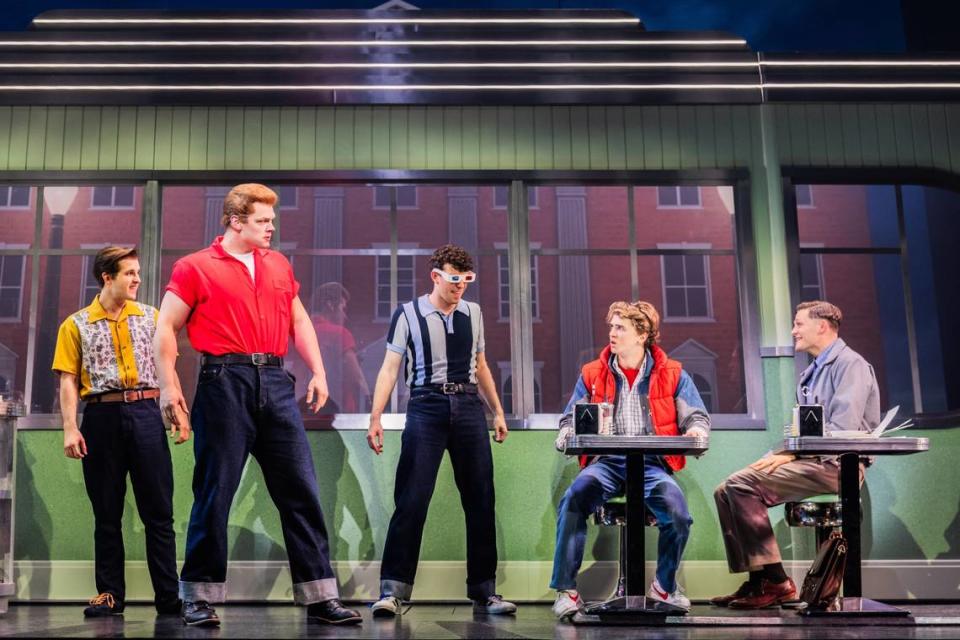 Ethan Rogers (red shirt, as Biff Tannen), Caden Brauch (second from right, as Marty McFly) and Burke Swanson (far right, as George McFly) lead the cast of the production of “Back to the Future: The Musical” that will be in Charlotte this month.