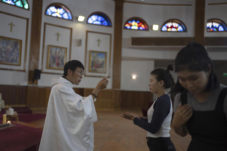 Sanjaajav Tserenkhand, the Assistant Priest of Saint Peter and Paul Cathedral, gives communion during a mass in Ulaanbaatar, Mongolia on Monday, Aug. 28, 2023. When Pope Francis travels to Mongolia this week, he will in some ways be completing a mission begun by the 13th century Pope Innocent IV, who dispatched emissaries east to ascertain the intentions of the rapidly expanding Mongol Empire and beseech its leaders to halt the bloodshed and convert. (AP Photo/Ng Han Guan)