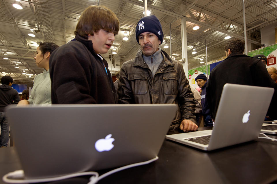 Black Friday shoppers check out Apple laptops on sale on Black Friday, November 25, 2011, at the Fair Lakes Best Buy store in Fairfax, Virginia. Immediately following the Thanksgiving holiday on the last Thursday of November, many Americans are off to the shopping malls for the pre-Christmas shopping melee known as Black Friday, when retailers slash prices on clothing, toys and consumer electronics.  So important is Black Friday to retailers -- potentially more than $20 billion in sales, according to the market analysis firm SpendingPulse -- that many big-name outlets are opening earlier than ever. During the original Thanksgiving in 1621 pilgrim settlers from England sat down with native Americans for a three-day feast in modern-day Massachusetts to thank God for bountiful harvests in the New World. AFP PHOTO Paul J. RICHARDS (Photo credit should read PAUL J. RICHARDS/AFP via Getty Images)
