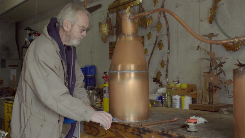 Don Owens, Cedar Mountain artist, welds a copper still.