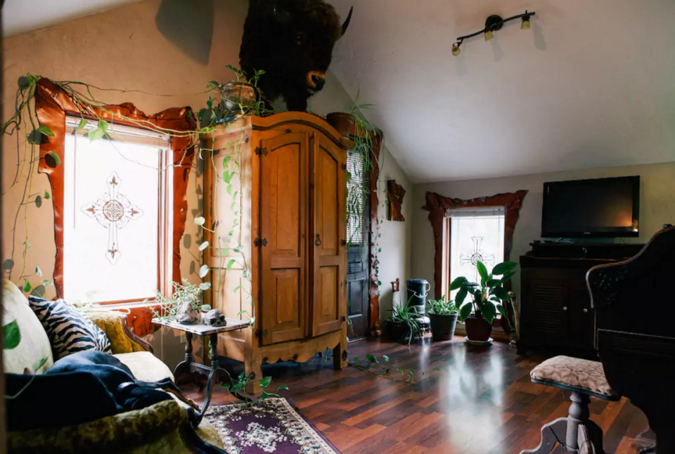 <p>The living room has fabulous wood floors and an armoire that looks like it is straight out of “The Conjuring.” (Airbnb) </p>