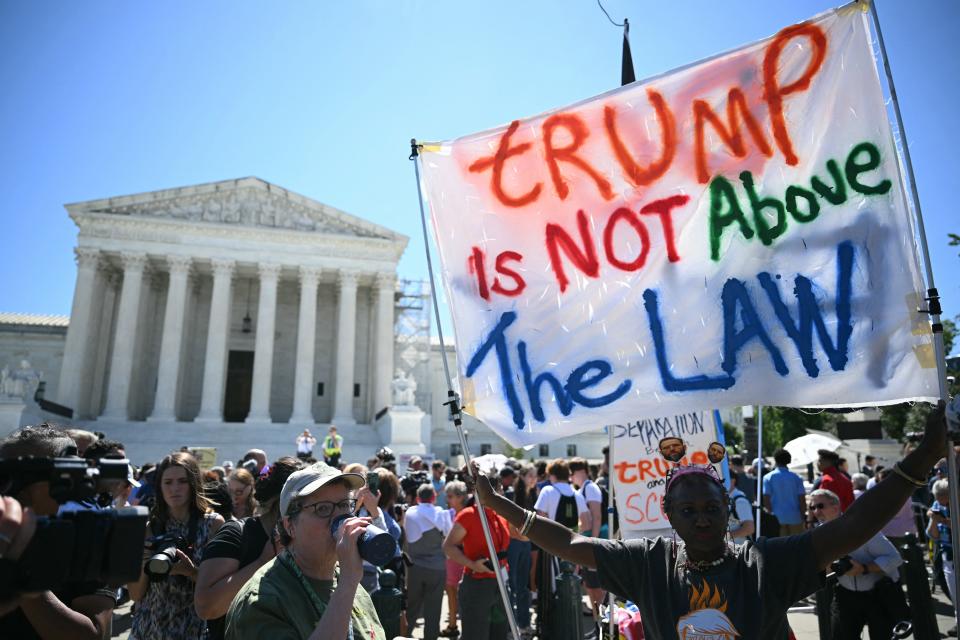 People hold anti Trump signs in front of the US Supreme Court on July 1, 2024, in Washington, DC. Donald Trump on Monday hailed a "big win" for democracy after the US Supreme Court ruled that presidents have at least presumptive immunity for official acts – a decision set to delay his trial for allegedly conspiring to overturn his 2020 election loss.