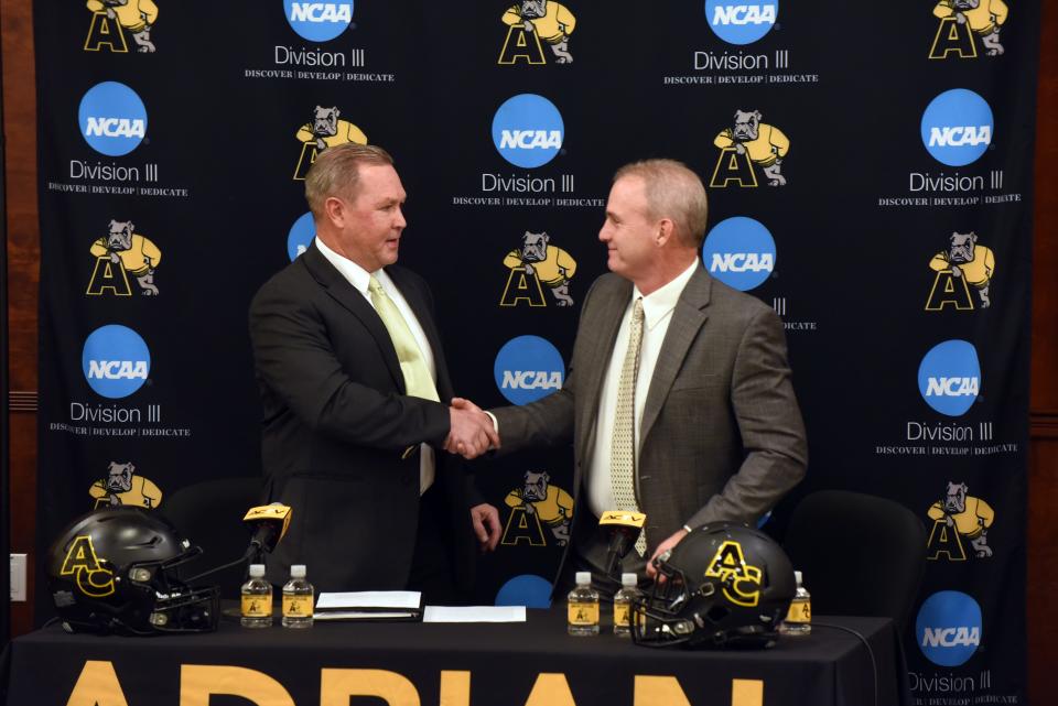 Adrian College athletics director Craig Rainey (left) and Joe Palka (right) shake hands during Monday's press conference.