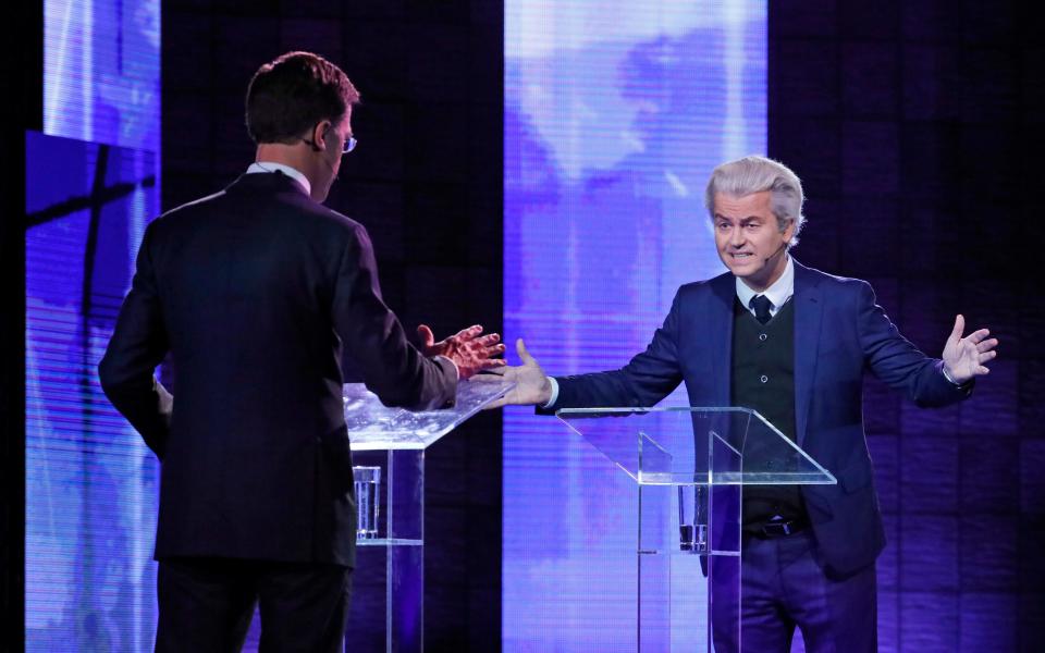 Right-wing populist leader Geert Wilders gestures as he talks to Dutch Prime Minister Mark Rutte, left, during a national televised debate - Credit: AP