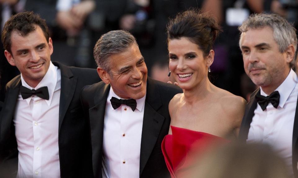 FILE - In this Aug. 28, 2013, from left, screenwriter Jonas Cuaron, actors Sandra Bullock, George Clooney and director Alfonso Cuaron pose for photographers as they arrive for the screening of "Gravity" at the 70th edition of the Venice Film Festival, in Venice, Italy. Bullock says making the lost-in-space movie “Gravity” with director Alfonso Cuaron was her “best life decision” ever. Bullock’s priority had been spending time with her son, who is now 3, and Cuaron assured her that she wouldn’t miss anything on the film, which also features George Clooney and lands in US theatres on Friday, Oct. 4, 2013. (AP Photo/David Azia, File)