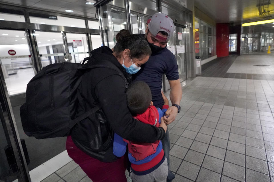 Celestina Ramirez, left, a migrant from Honduras, and her son, Yancarlos Amaya, 5, are hugged by Ramirez's brother Marco Ramirez after they are reunited at Baltimore-Washington International Thurgood Marshall Airport, in Linthicum, Md., Wednesday, March 24, 2021. The mother and son arrived in Baltimore after they were allowed to stay in the U.S. upon turning themselves in to U.S. Customs and Border Protection at the border. (AP Photo/Julio Cortez)