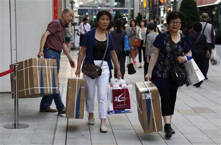 Chinese tourists carry packages of Panasonic Corp's washlet along Tokyo's Ginza Shopping district May 16, 2014. REUTERS/Yuya Shino