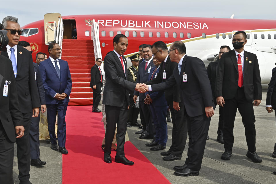 In this photo released by Malaysia's Department of Information, Indonesian president Joko Widodo, center, is greeted by representatives from Malaysian government upon the arrival at KLIA international airport in Sepang, Malaysia Wednesday, June 7, 2023. (Malaysia's Department of Information via AP)