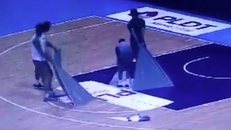 Aussie officials are filmed removing floor decals from the court. Pic: Twitter