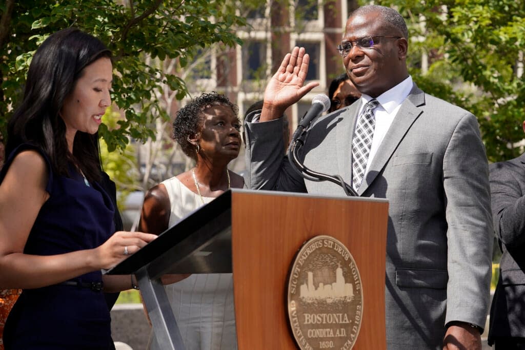 Michael Cox, right, raises his hand as he is sworn in as commissioner of the Boston police department by Mayor Michelle Wu, left, Monday, Aug. 15, 2022, in Boston.(AP Photo/Steven Senne)