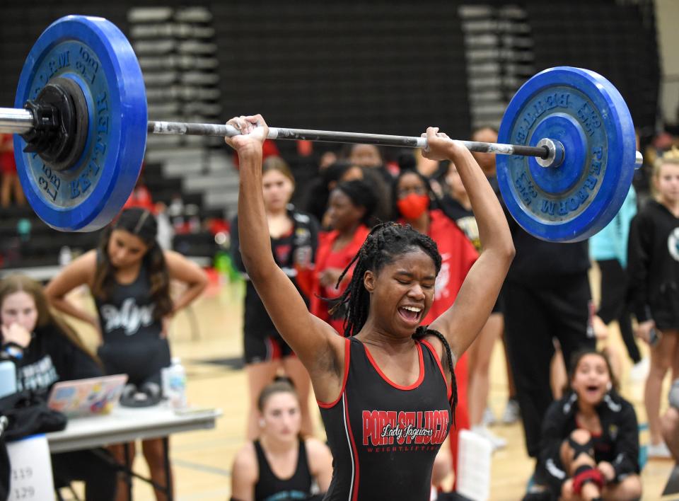 Bernadine Estinoble, of Port St. Lucie High School, reacts after successfully lifting 120 pounds in the 119-129 pound class clean and jerk competition during the Girls Weight Lifting Class 2A District 16 meet on Friday, Jan. 21, 2022, at Jensen Beach High School. 