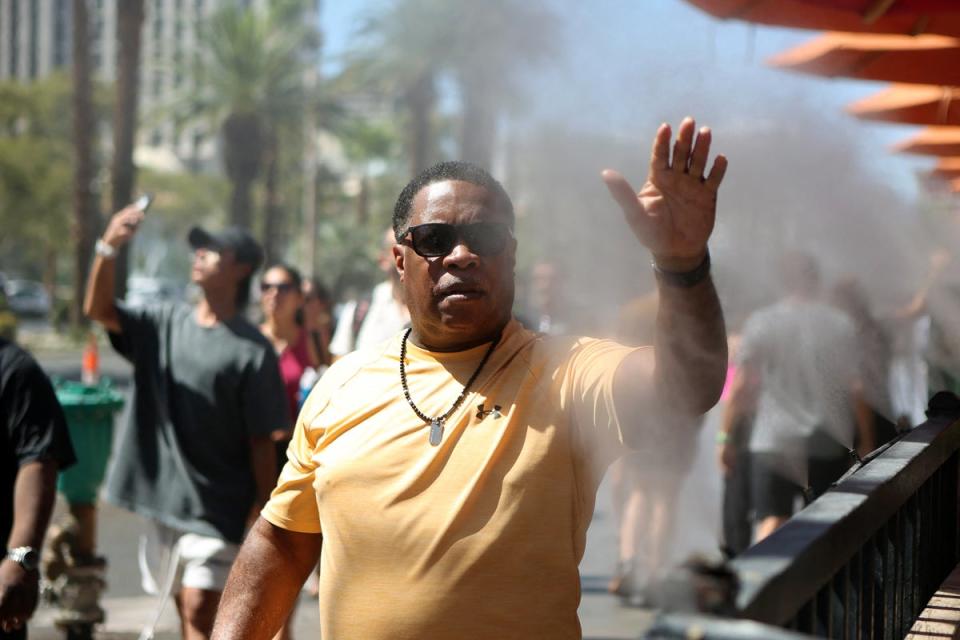 A pedestrian cools off in water sprinklers along the sidewalk during a heat wave in Las Vegas, Nevada last week (AFP via Getty Images)