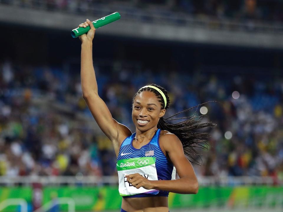 Allyson Felix holds up a baton at the Rio Olympics in 2016.