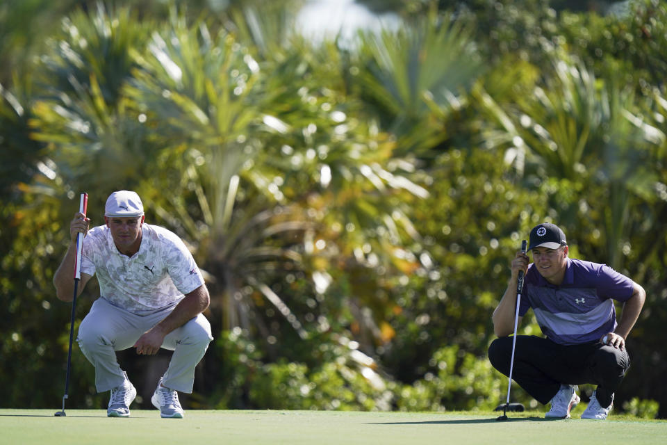 Bryson DeChambeau, left, and Jordan Spieth, of the United States, study their putt lines during the first round of the Hero World Challenge PGA Tour at the Albany Golf Club, in New Providence, Bahamas, Thursday, Dec. 2, 2021.(AP Photo/Fernando Llano)