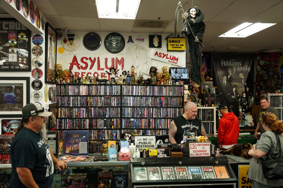 People linger at the checkout counter at Asylum Records on August 19, 2023, in Chandler, AZ.