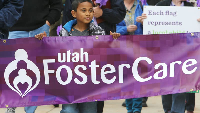 Tayler Sumsion walks with his family and others around the Salt Lake City-County Building to honor foster care families as part of National Foster Care Month on May 9, 2014.