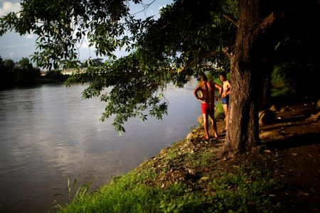 Men stand beside the Suchiate river in Ciudad Hidalgo