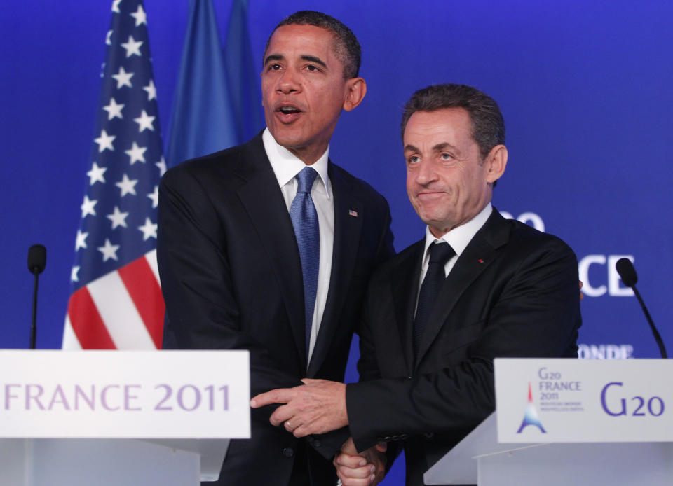 FILE - In this Nov.3, 2011 file photo, U.S. President Barack Obama, left, and French President Nicolas Sarkozy shake hands after they made statements to reporters after their meeting at the G20 Summit in Cannes, southern France. A Paris court on Monday found French former President Nicolas Sarkozy guilty of corruption and influence peddling and sentenced him to one year in prison and a two-year suspended sentence. The 66-year-old politician, who was president from 2007 to 2012, was convicted for having tried to illegally obtain information from a senior magistrate in 2014 about a legal action in which he was involved.(AP Photo/Charles Dharapak, File)