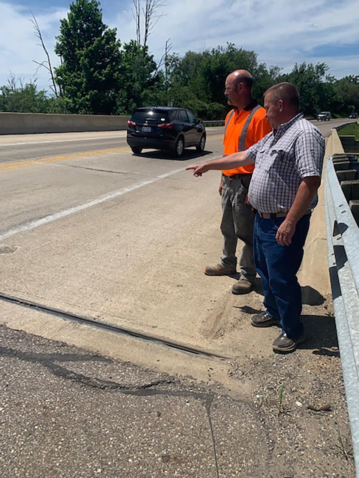 John Lindsey, manager of St. Joseph County Road Commission, and engineering technician Don Preston look at the east end of the M-86 bridge over Prairie River. Michigan Department of Transportation plans to correct a dip at the bridge in early September.