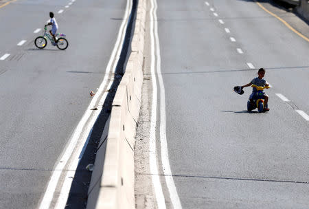 Children ride their bicycles in an empty street in Jerusalem during the Jewish holiday of Yom Kippur, September 19, 2018. Most Israeli Jews refrain from driving during the 25-hour period. REUTERS/Ammar Awad