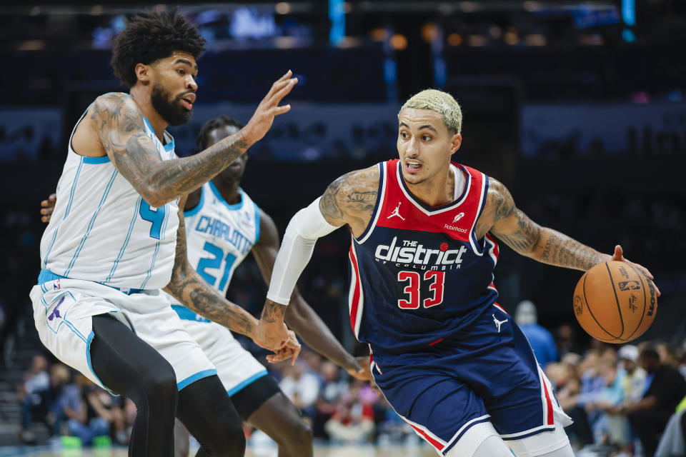 Washington Wizards forward Kyle Kuzma (33) drives against Charlotte Hornets center Nick Richards during the first half of an NBA basketball game in Charlotte, N.C., Wednesday, Nov. 8, 2023. (AP Photo/Nell Redmond)