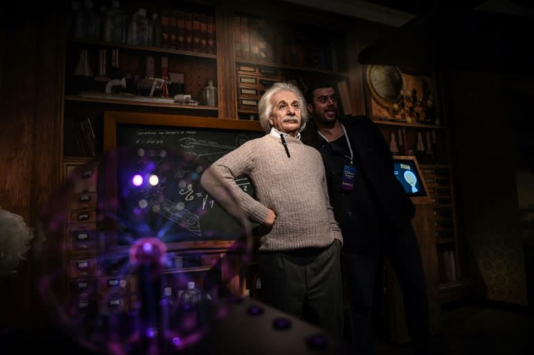 A man poses next to a wax statue of German-born physicist Albert Einstein on November 22, 2016 at Madame Tussauds wax museum in Istanbul