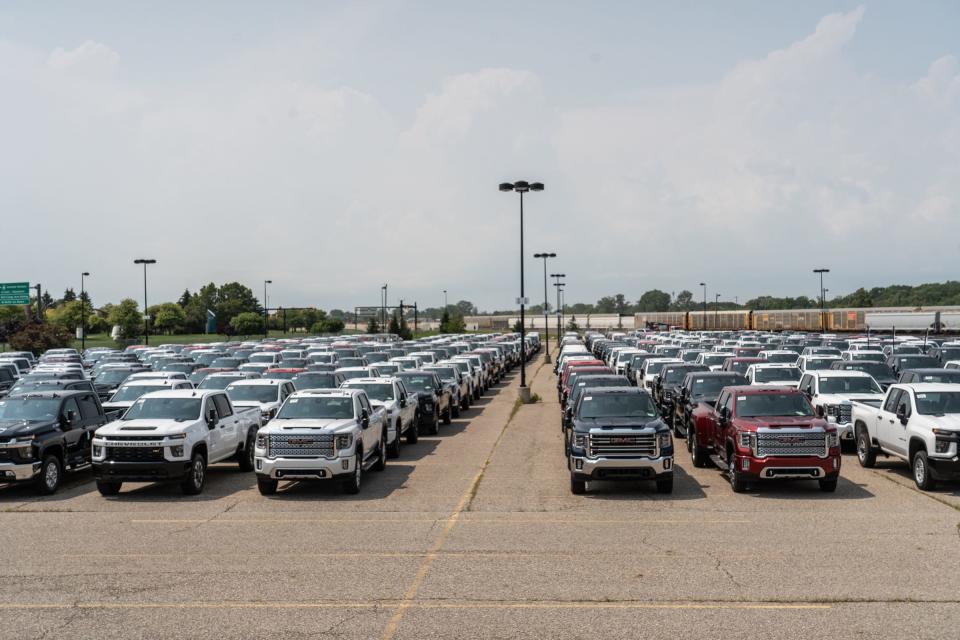 General Motors trucks sit in a gated parking lot next to the Economy Lot across from Bishop International Airport in Flint on August 11, 2021.