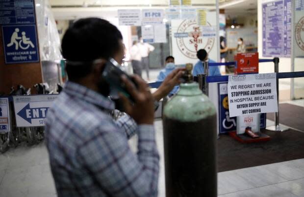 A man stands next to a notice outside a hospital in New Delhi, India on Thursday. A dire shortage of oxygen has meant states are closely guarding their supplies and even posting armed police at production plants to ensure security.