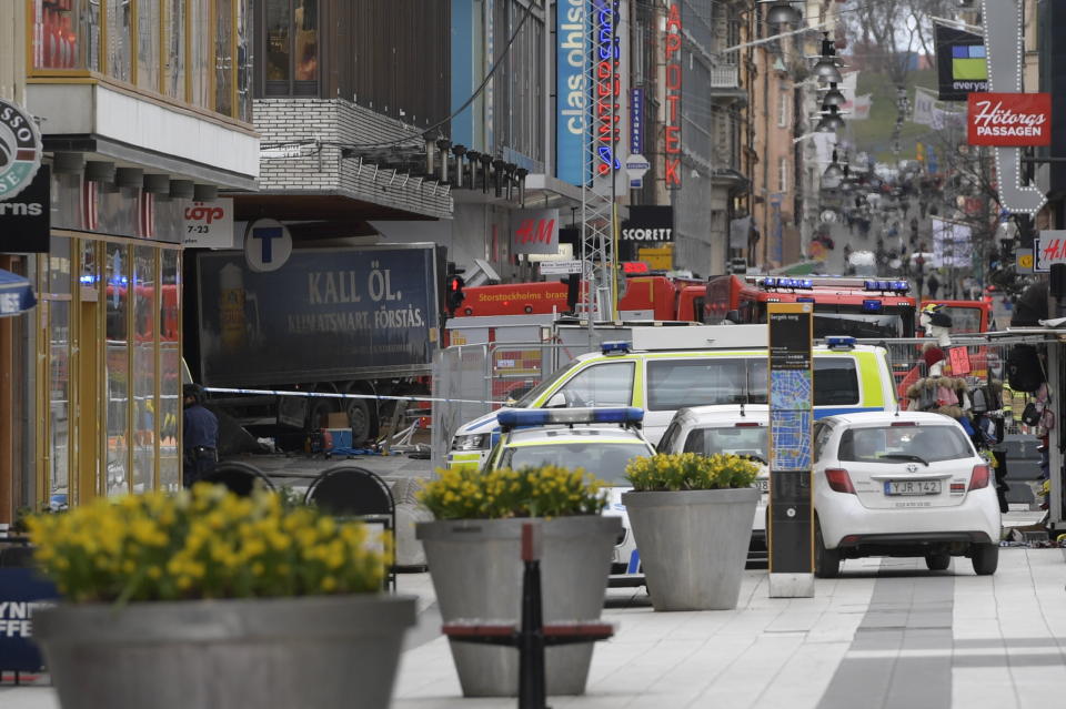 A la izquierda se ve la parte trasera de un camión que se estrelló contra una tienda departamental en el centro de Estocolmo, dejando al menos tres personas muertas y varios heridos, en Suecia, el viernes 7 de abril de 2017. El primer ministro Stefan Lofven dice que todo indica que se trató de un "ataque terrorista". (Anders Wiklund , TT News Agency via AP)