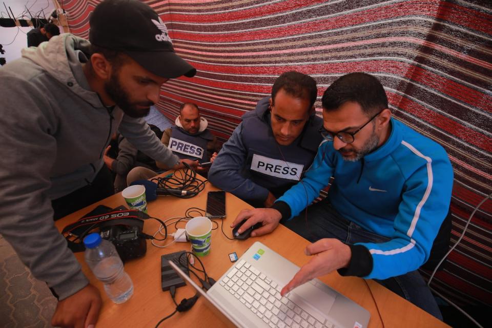 Palestinian journalists from Gaza gather in Hamad at a school which is being used to house people forced from their homes.