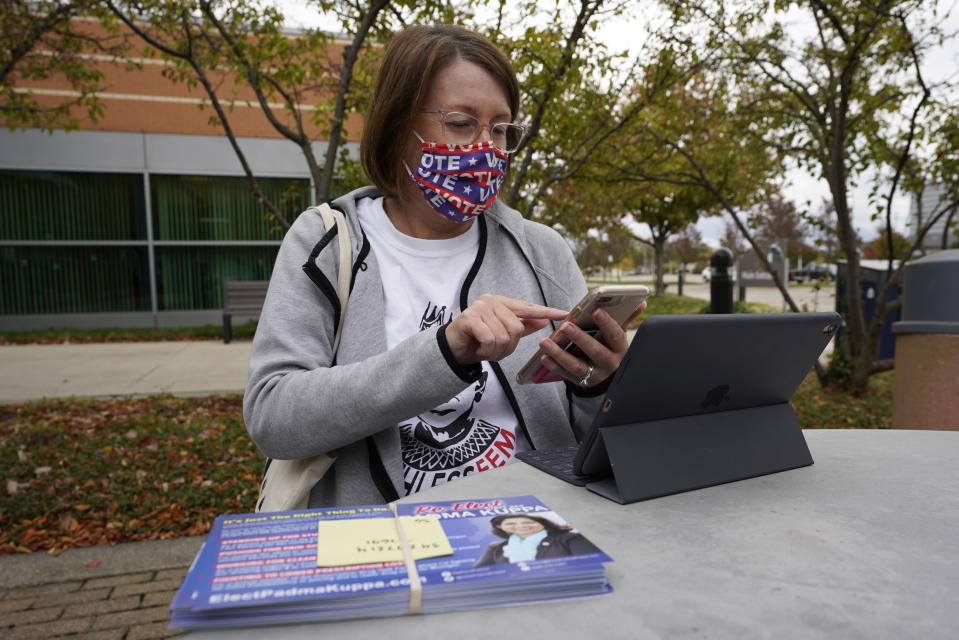 Julie Campbell-Bode, prepares to canvas for Democratic voters in Troy, Mich., Thursday, Oct. 15, 2020. In Michigan, women have cast nearly 56% of the early vote so far, and 68.1 percent of those were Democrats, according to the voting data firm L2. (AP Photo/Paul Sancya)