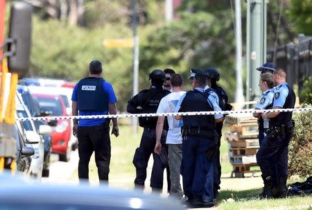 Police officers are seen behind a road block at the scene of a shooting in the western Sydney suburb of Ingleburn, Australia, March 7, 2016. REUTERS/Dan Himbrechts/AAP