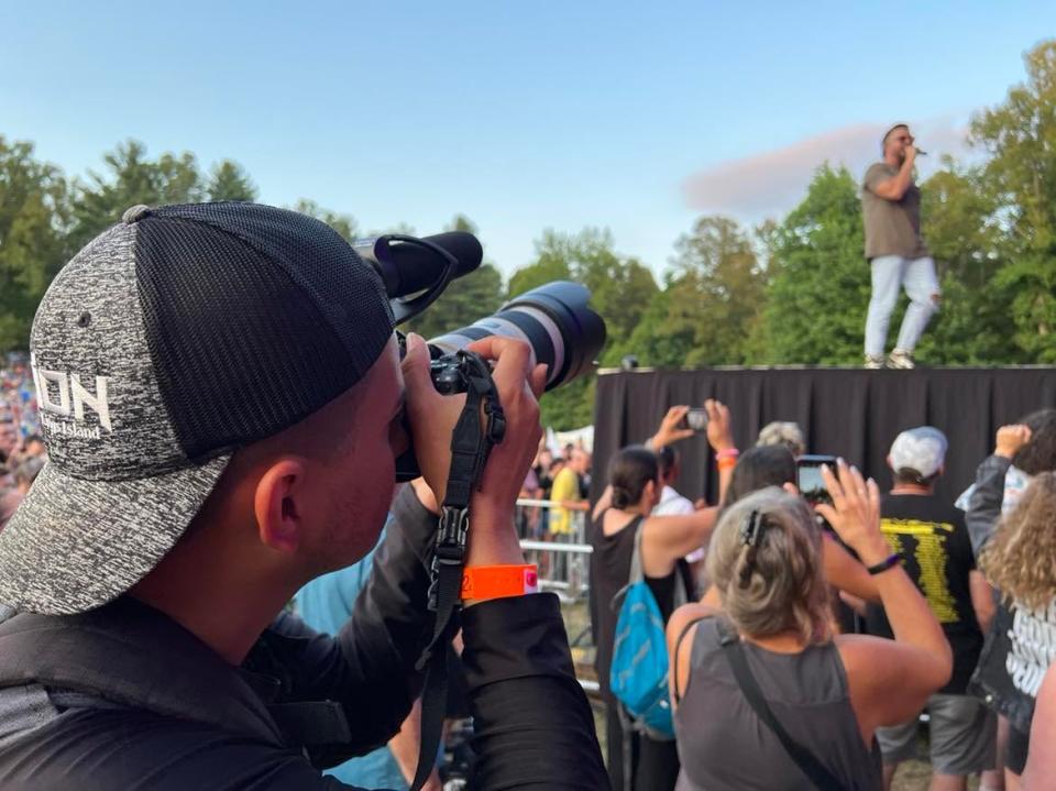 A concertgoer at the Alive Music Festival takes photos of Danny Gokey during his Thursday night performance on the first day of the event, which continues through Sunday.