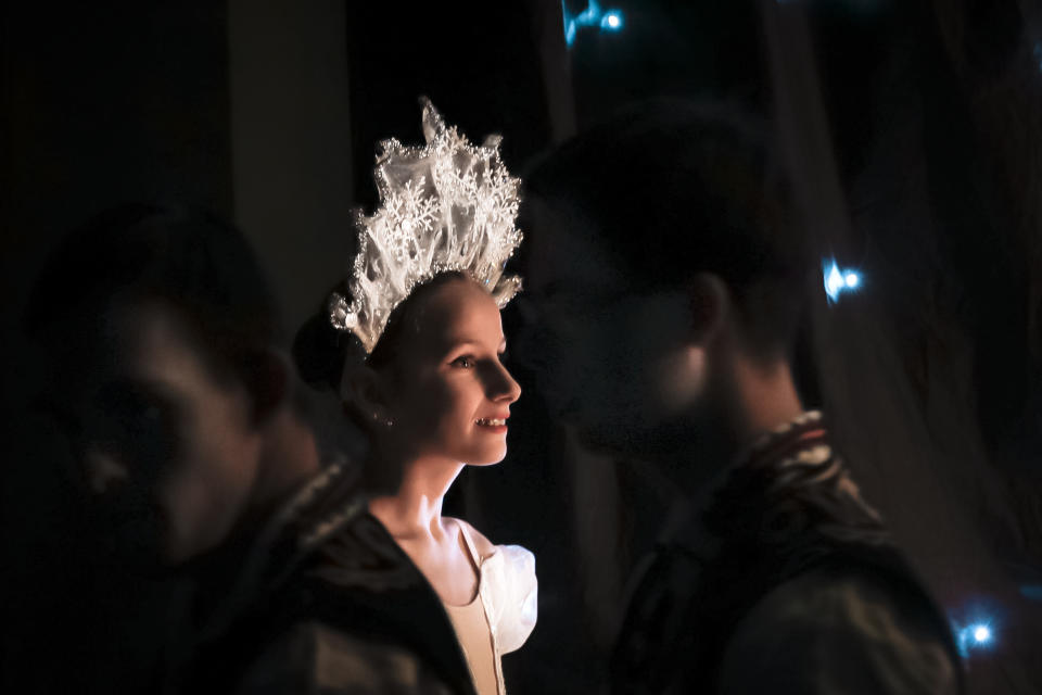 In this Dec. 3, 2019, photograph a ballerina of the Arabesque Children's Ballet Ensemble, smiles before going on stage as children with Down syndrome pass by, in Bucharest, Romania.(AP Photo/Vadim Ghirda)