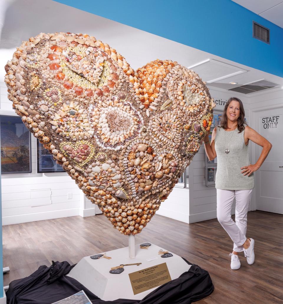 Ginny Dickinson stands next to the heart she made out of seashells, mostly from Sanibel Island. It is on display in the Sanibel & Captiva Islands Visitors Center, which will reopen on June 6.