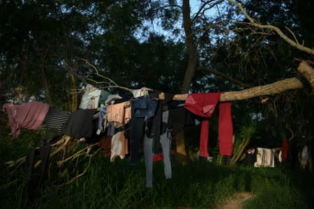 The clothes of asylum seekers dry in trees near a makeshift migrant camp by the Gateway International Bridge in Matamoros