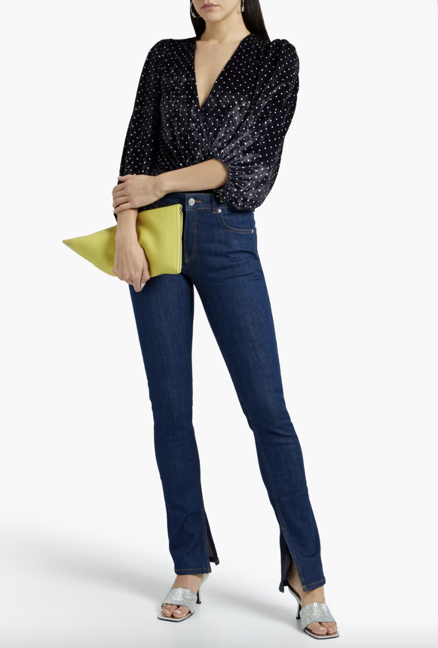 model in blue jeans and black Ganni Wrap-Effect Polka-Dot Velvet Bodysuit (Photo via The Outnet)