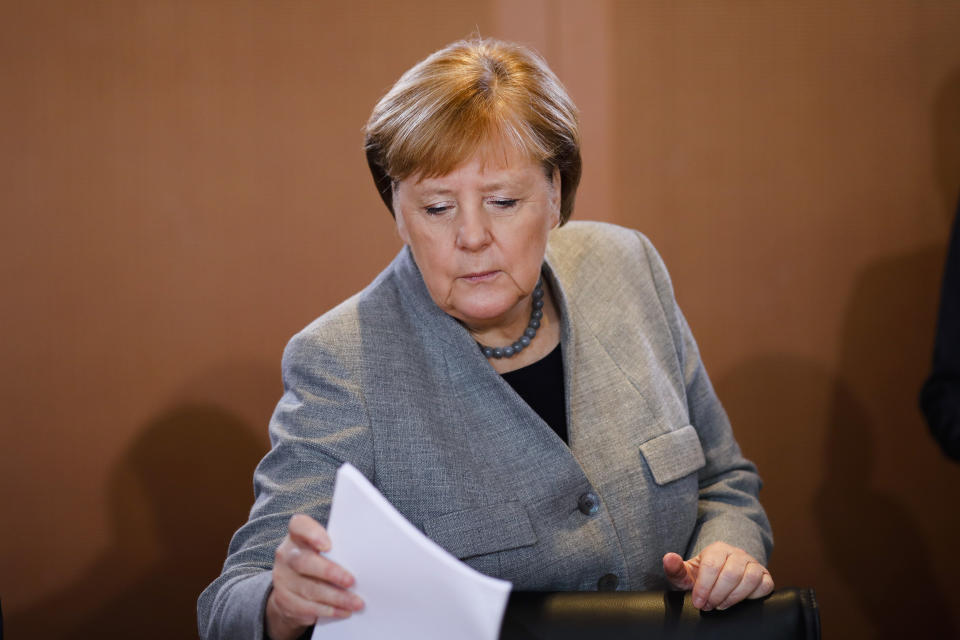 German Chancellor Angela Merkel takes some documents as she arrives for the weekly cabinet meeting of the German government at the chancellery in Berlin, Wednesday, Jan. 15, 2020. (AP Photo/Markus Schreiber)