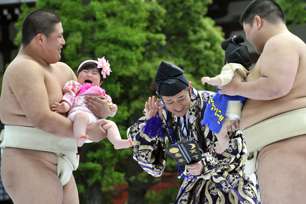 Student sumo wrestlers carry crying babies during the "Baby-cry Sumo" competition at Tokyo's Sensoji temple on April 30, 2011. Some 50 babies aged under one participated in the annual baby crying contest. Japanese parents believe that sumo wrestlers can help make babies cry out a wish to grow up with good health. AFP PHOTO/Yoshikazu TSUNO