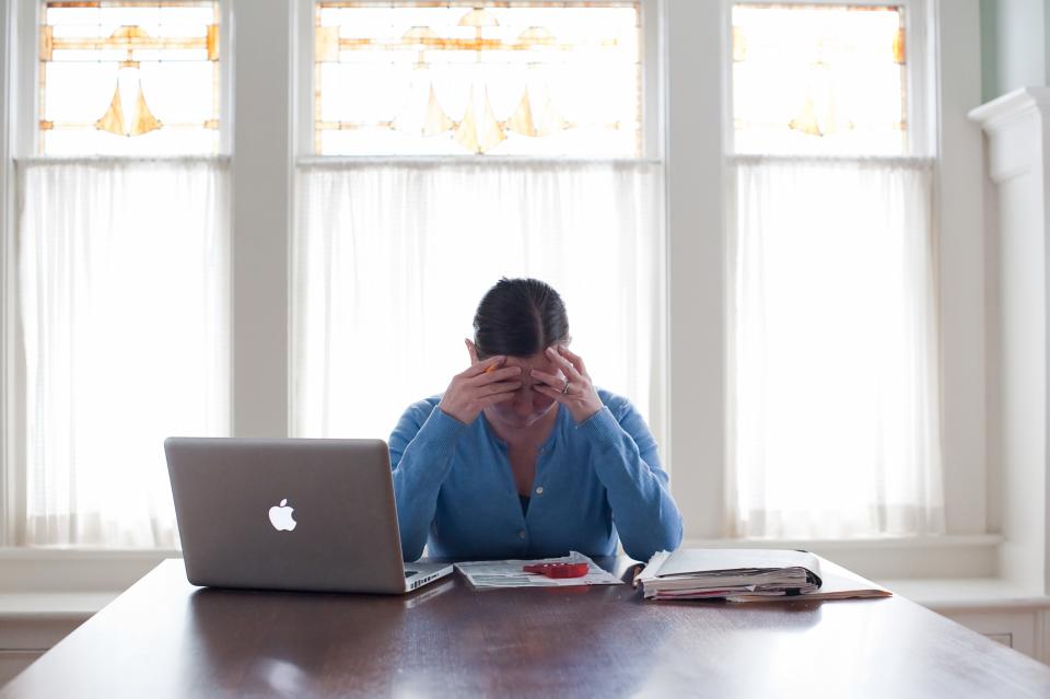 A woman struggles to fill out tax forms. 