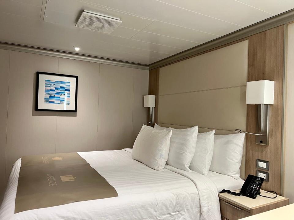 Bed with different pillows inside stateroom on Holland America Line Rotterdam