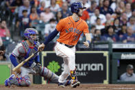 Houston Astros' Kyle Tucker watches his RBI single in front of Texas Rangers catcher Jose Trevino during the second inning of a baseball game Friday, May 14, 2021, in Houston. (AP Photo/Michael Wyke)