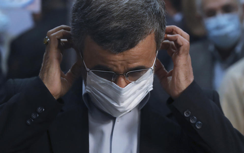 Former Iranian President Mahmoud Ahmadinejad wears his mask while registering his name as a candidate for the June 18 presidential elections at the elections headquarters of the Interior Ministry in Tehran, Iran, Wednesday, May 12, 2021. The country's former firebrand president will run again for office in upcoming elections in June. The Holocaust-denying Ahmadinejad has previously been banned from running for the presidency by Supreme Leader Ayatollah Ali Khamenei in 2017, although then, he registered anyway. (AP Photo/Vahid Salemi)