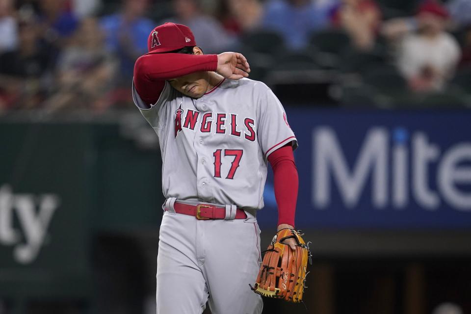 Los Angeles Angels starting pitcher Shohei Ohtani wipes his face with his arm sleeve as he works against the Texas Rangers during the sixth inning of a baseball game Wednesday, May 18, 2022, in Arlington, Texas. (AP Photo/Tony Gutierrez)