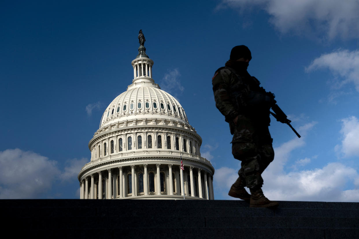 A member of the National Guard on patrol, with the Capitol in the background.