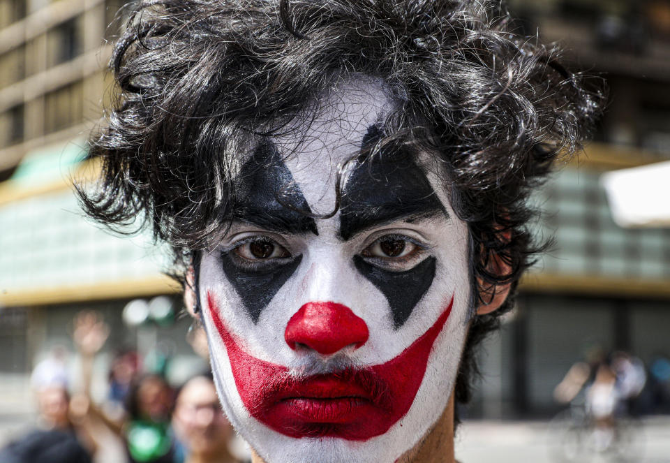 A street clown joins a protest against President Sebastian Piñera’s government, at the Plaza de Armas in Santiago, Chile, Wednesday, Oct. 23, 2019. Rioting, arson attacks and violent clashes wracked Chile as the government raised the death toll in an upheaval that has almost paralyzed the South American country long seen as the region's oasis of stability. (AP Photo/Esteban Felix)