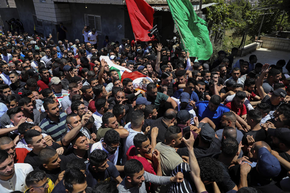 Palestinian mourners carry the body of Obaida Jawabreh, who was killed in clashes with Israeli forces, during his funeral in the West Bank refugee camp of Al-Arrub, Tuesday, May 18, 2021. (AP Photo/Mahmoud Illean)